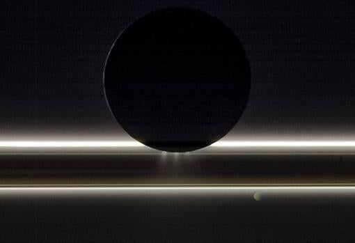 Encélado, la luna de Saturno, se desplaza ante los anillos y la pequeña luna Pandora en esta vista que la nave Cassini de la NASA capturó el 1 de noviembre de 2009