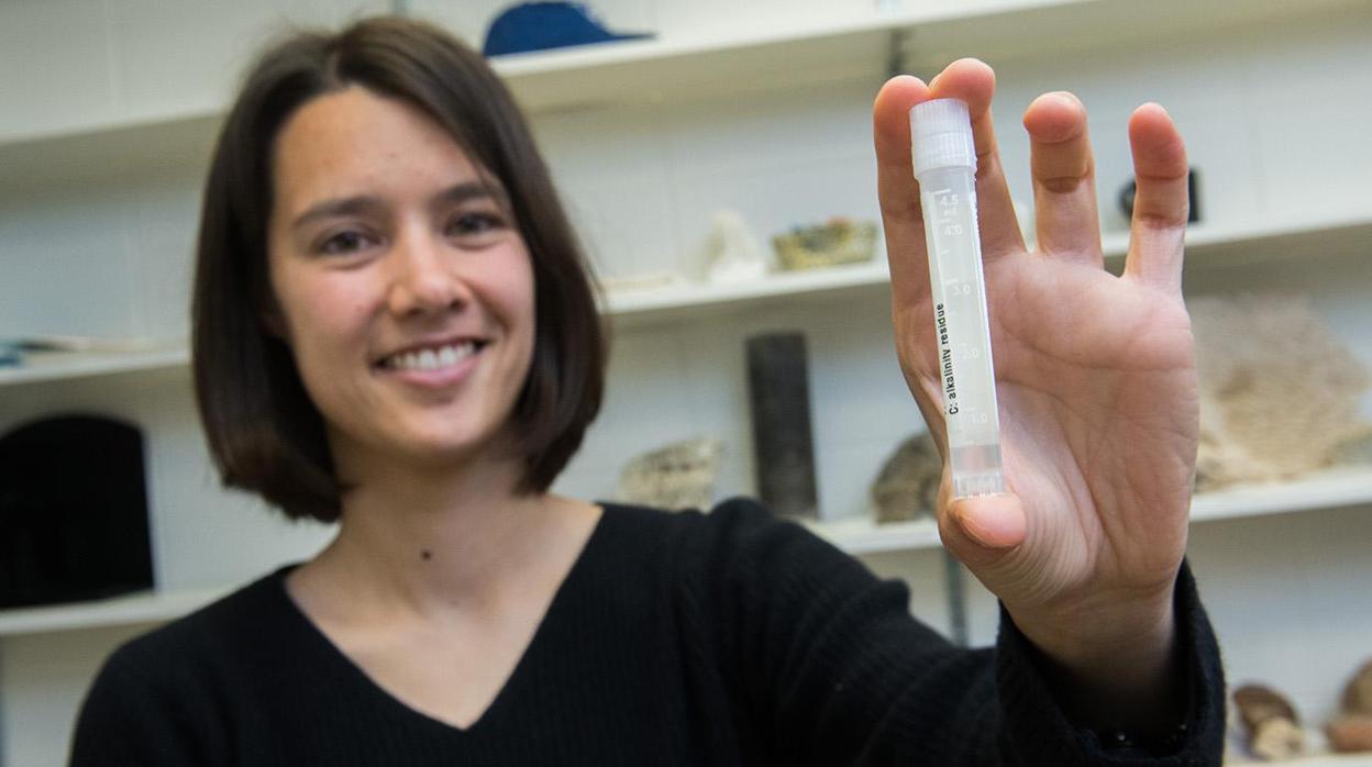 La investigadora Clara Blättler sostiene un tubo con agua de un océano que existió hace 20.000 años