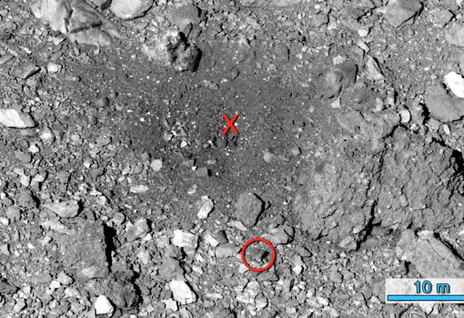 El sitio de Nightingale después del evento de recogida de muestras. La 'X' roja indica la ubicación aproximada donde OSIRIS-REx entró en contacto con la superficie del asteroide. El círculo rojo muestra la misma roca que estaba rodeada en la imagen anterior
