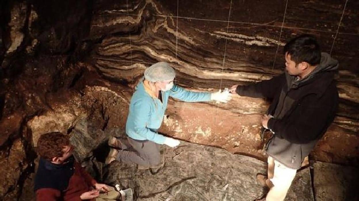 Varios miembros del equipo recogen muestras de sedimento en la cueva de Denisova
