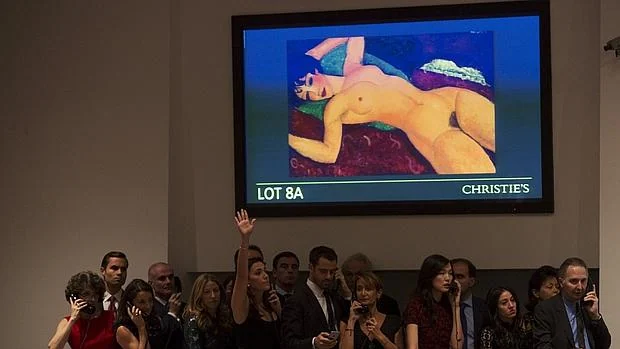 Una trabajadora de Christie's, que representa a un cliente, puja durante la subasta de «Nu Couche», de Amedeo Modigliani
