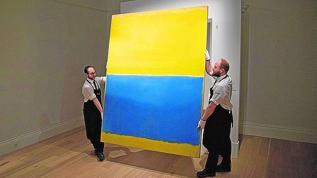 Dos empleados de Sotheby's sostienen «Untitled (Yellow and Blue)», obra de Rothko subastada el año pasado