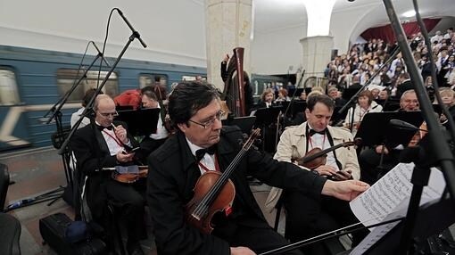 Miembros de la orquesta con el metro y el coro al fondo