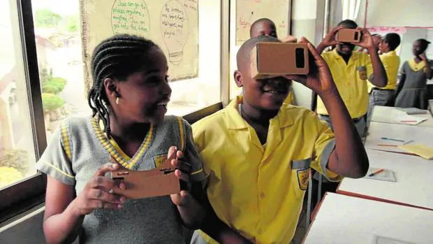 Niños usando el dispositivo de realidad virtual Google Cardboard como herramienta educativa en una clase