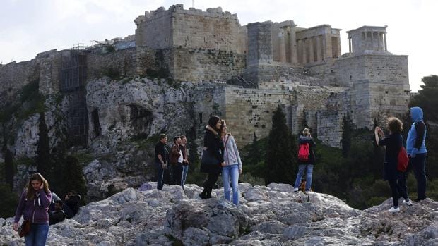 Turistas toman fotografías de la Acrópolis desde la colina Pnyka
