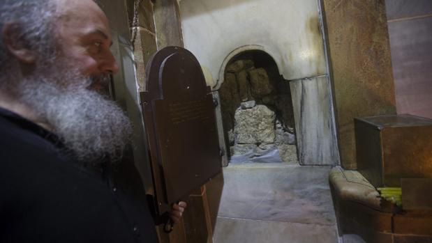 Un clero griego ortodoxo, fotografiado delante de la tumba de Jesucristo, en la Iglesia de la Santa Sepultura