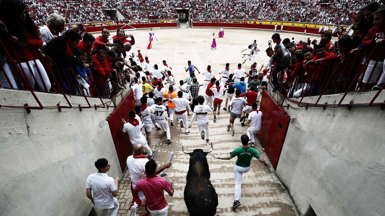 Un toro de Núñez del Cuvillo empuja a un corredor en el encierro