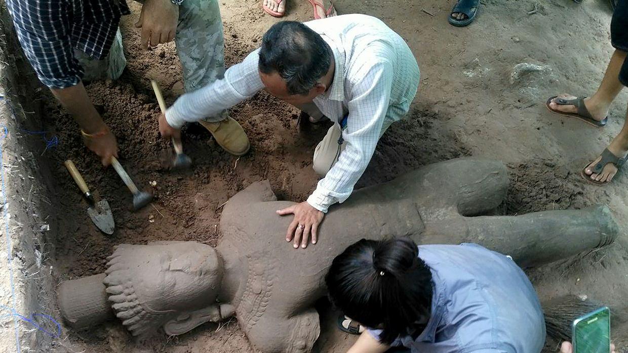 Arqueólogos desenterrando la estatua en el complejo monumental de Angkor