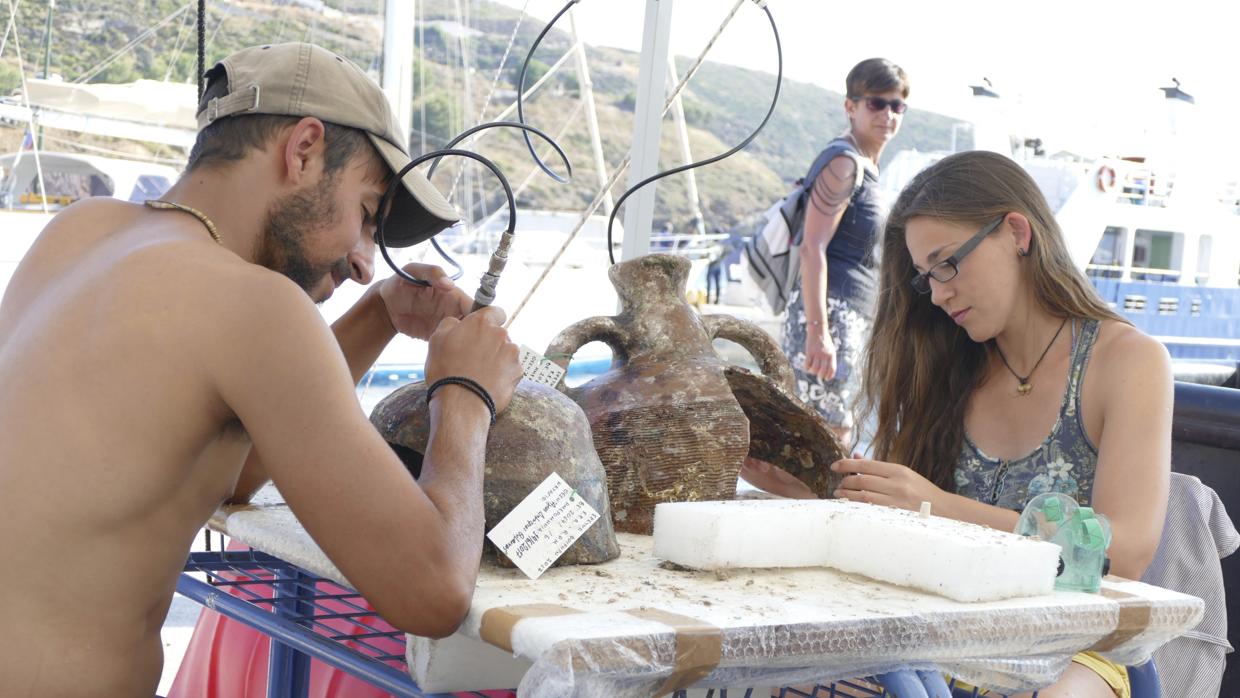 Unos arqueólogos limpian objetos extraídos de uno de los hallazgos del archipiélago de Furni, en el mar Egeo oriental