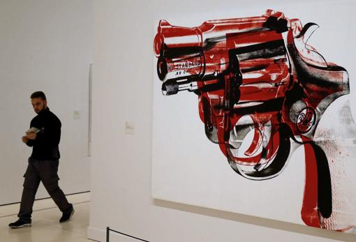Un hombre pasa ante la obra «Pistola» (1981), de Andy Warhol