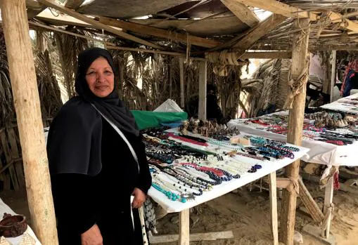 La beduina Soraya Ahmed, de 69 años, posa delante de su pequeña tienda en la que vende artesanía