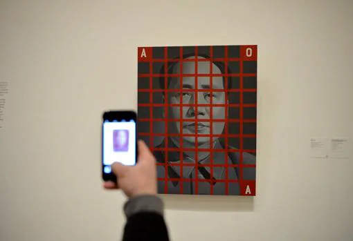 Un visitante hace una foto con su móvil a «Mao Zedong: cuadrícula roja nº 2», de Wang Guangyi