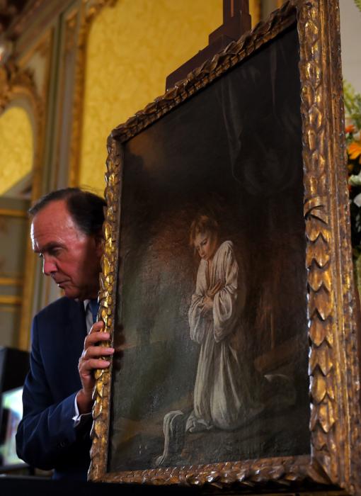 El subastador francés Philippe Rouillac sostiene el cuadro de los hermanos Le Nain