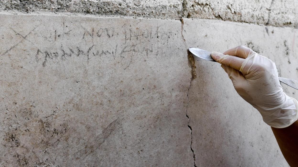 Una arqueóloga señala la inscripción encontrada en una domus de Pompeya