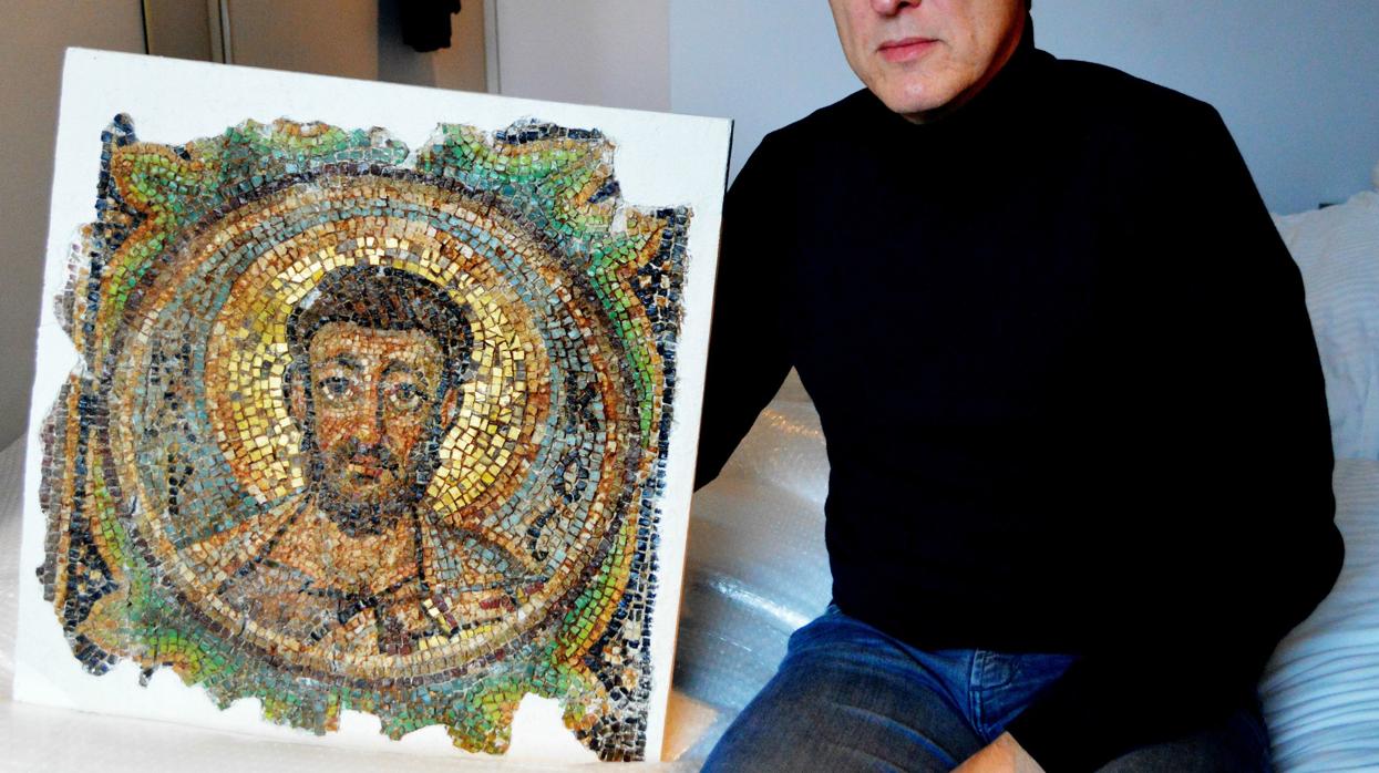 El detective de arte holandés Arthur Brand posa con el mosaico recuperado