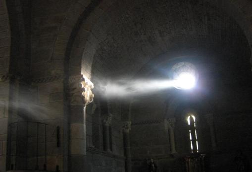 La luz entra por el óculo del hastial e ilumina un capitel de la iglesia