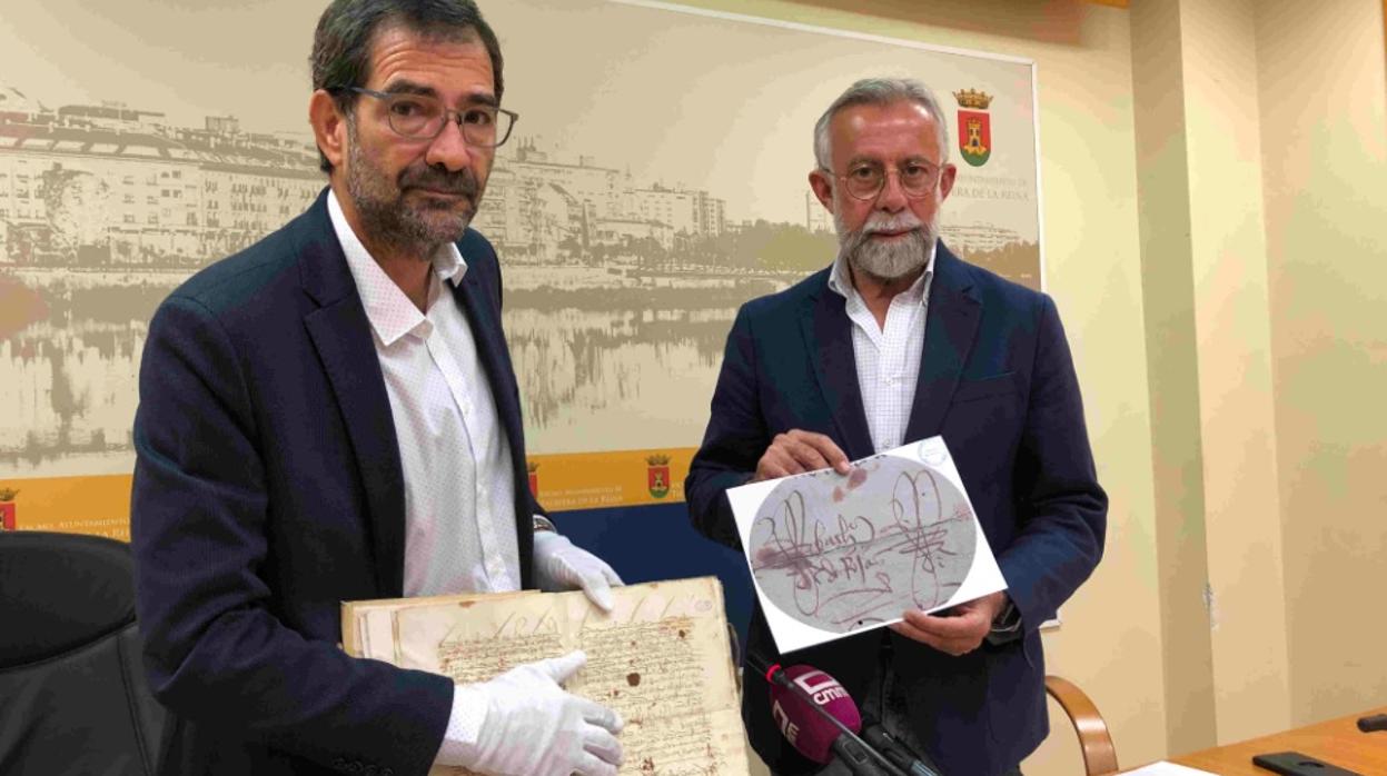 El alcalde Jaime Ramos, con el archivero municipal, Rafael Gómez, muestran la firma de Fernando de Rojas