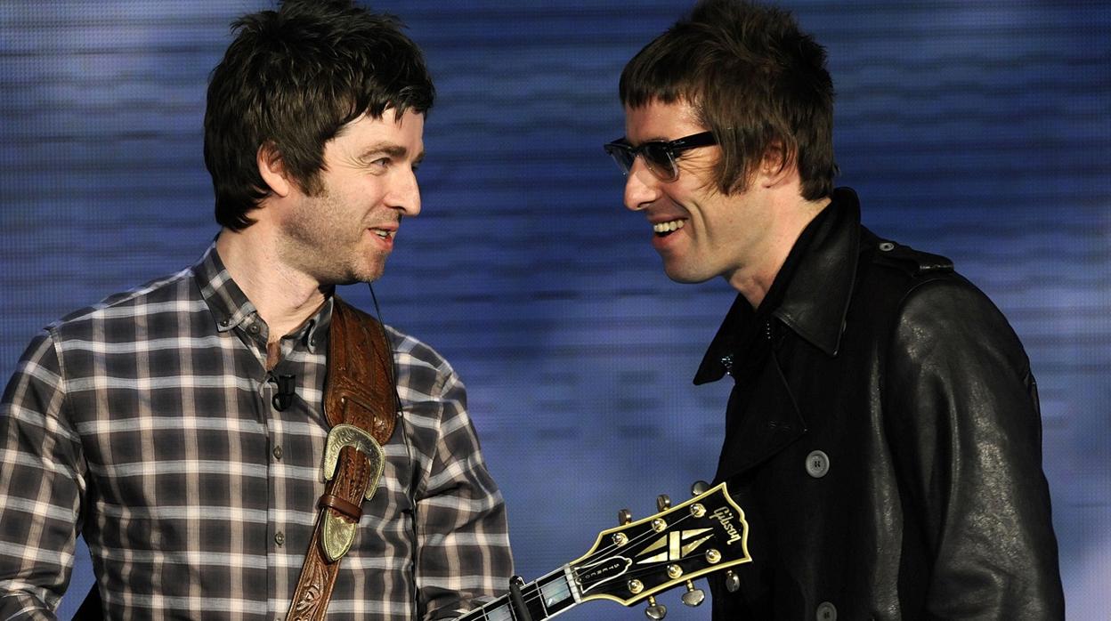 Los hermanos Gallagher, de Oasis, sonriéndose en medio de un concierto