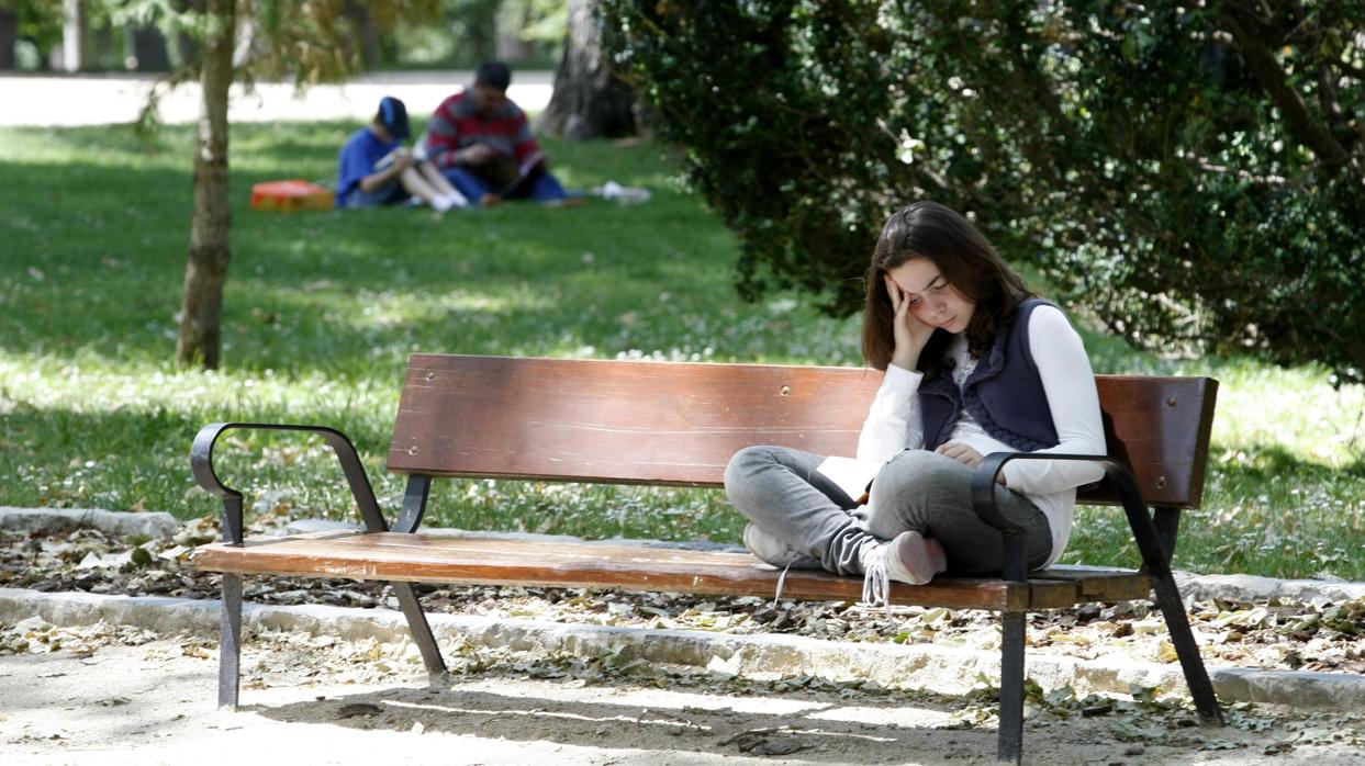 Joven leyendo en El Retiro, sede de la Feria del Libro