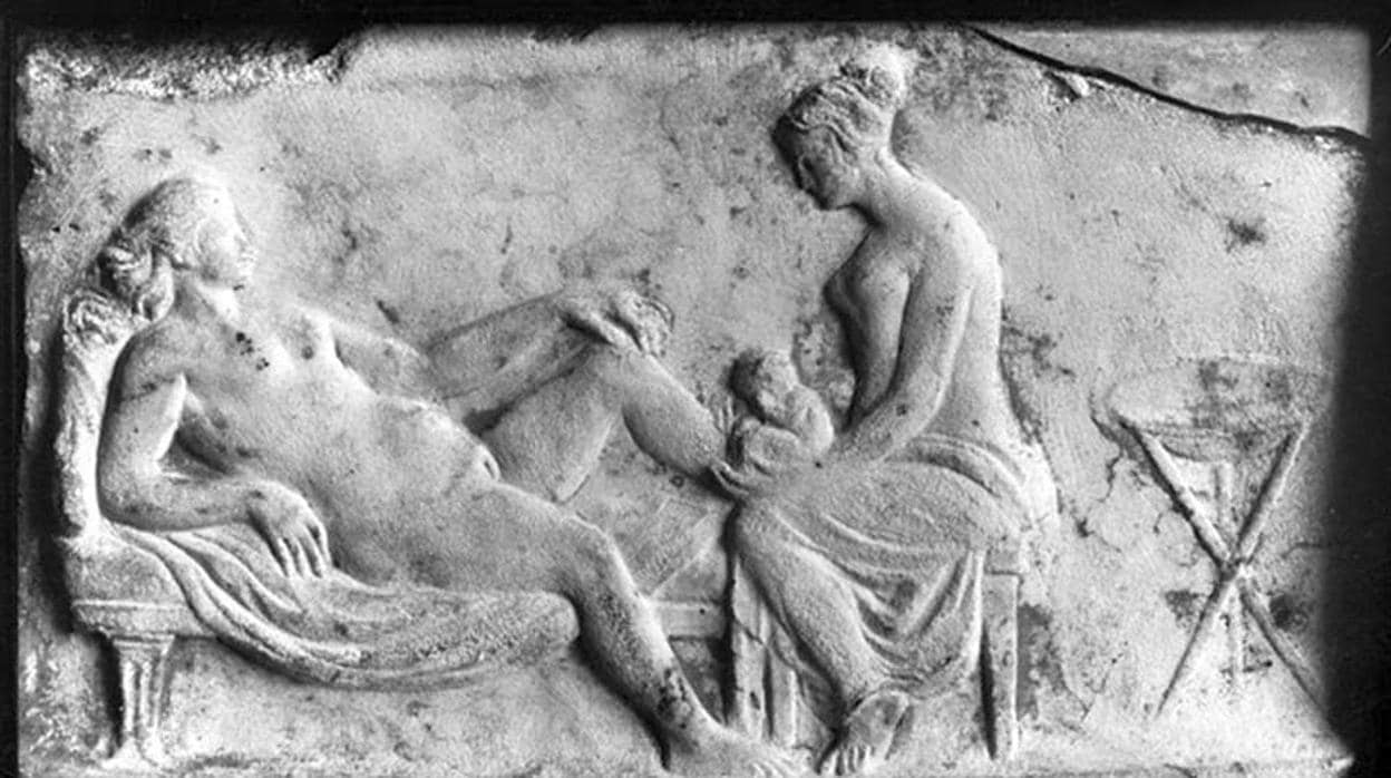 Relieve romano con la imagen de una comadrona asistiendo a una mujer en el parto.