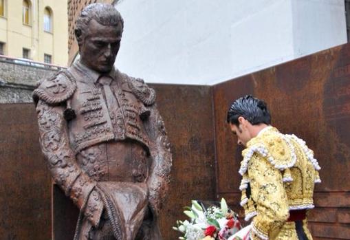 Emilio de Justo, con un ramo de flores ante la estatua a Iván Fandiño en Vista Alegre