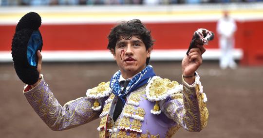 Luis David, con el labio partido, pasea la oreja del tercer toro