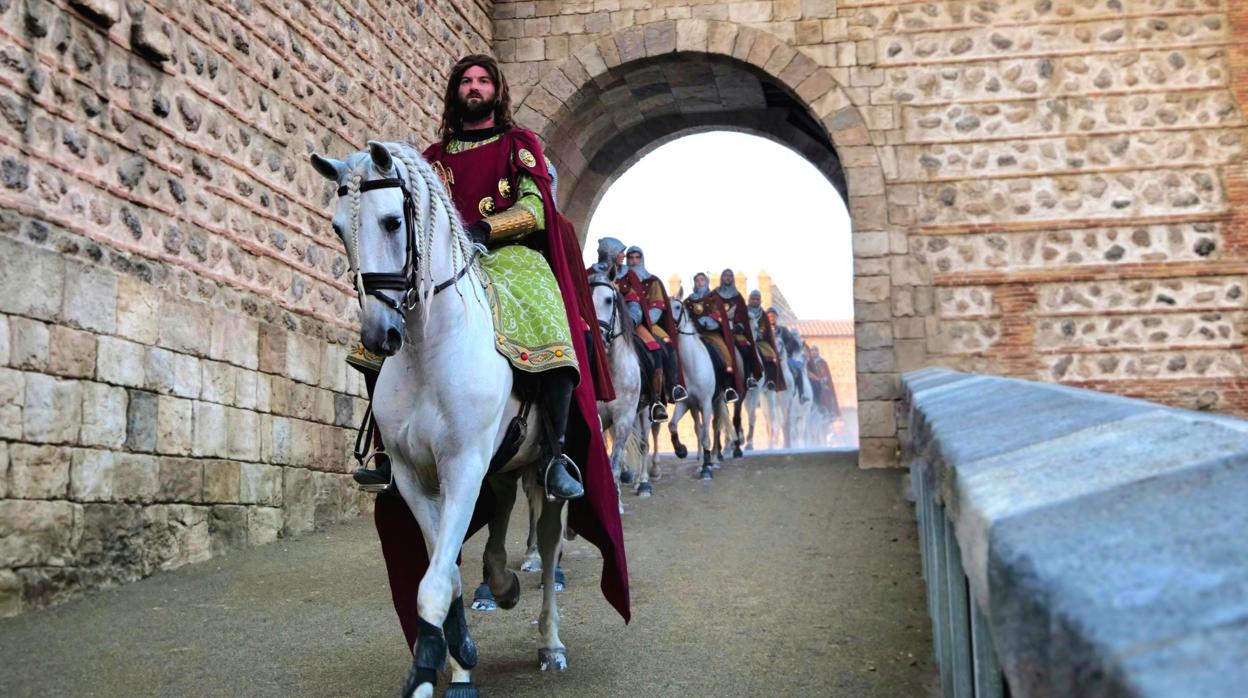 Un grupo de jinetes medievales atraviesa la puerta del puente de Alcántara de Toledo