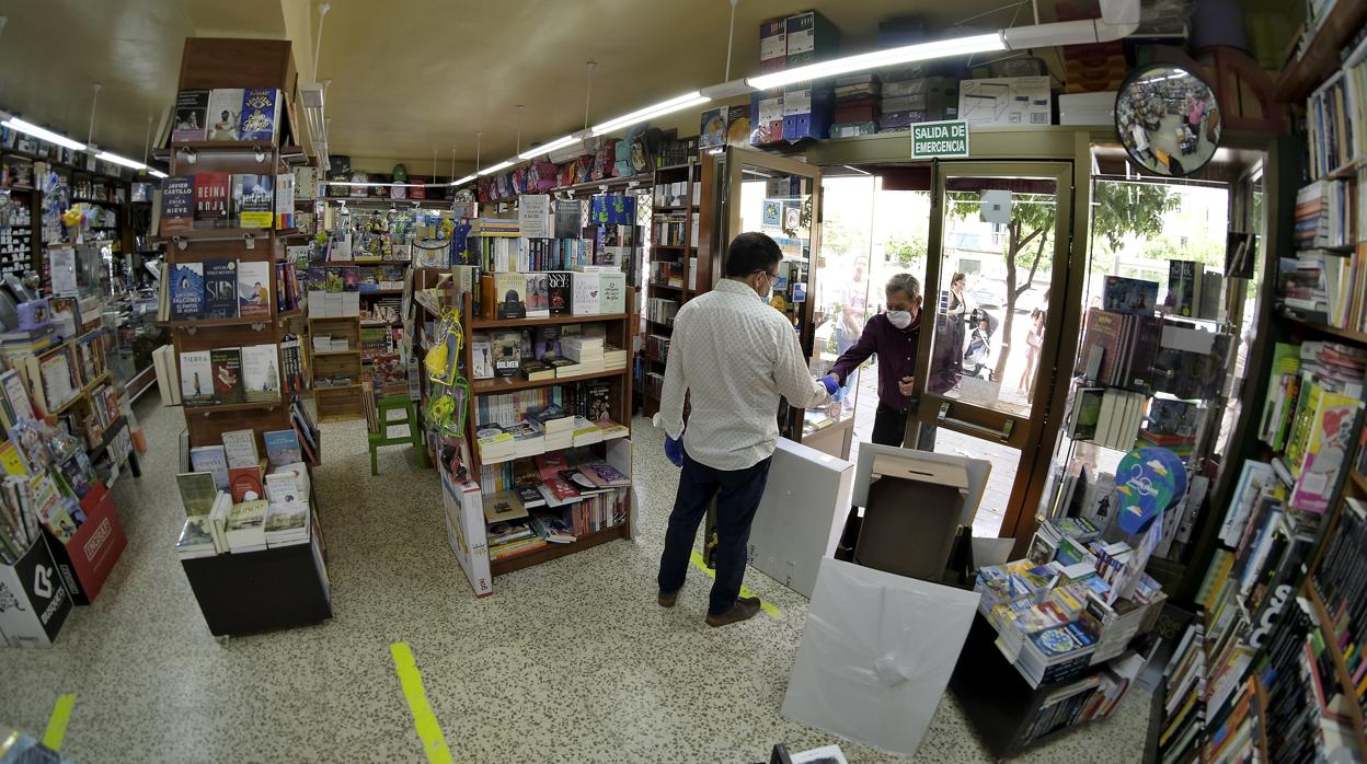 El propietario de la librería Tagore atiende a un cliente a la puerta de su establecimiento