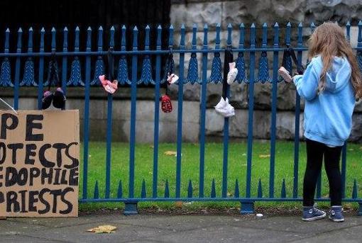 Zapatos de niños colgados a la entrada de la Catedral de Dublín como protesta simbólica contra la pederastia