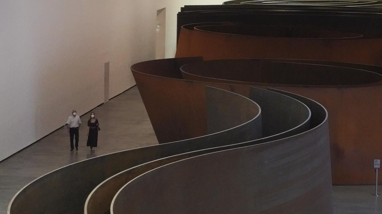 Dos visitantes, ayer junto a la obra "La materia del tiempo" de Richard Serra en el Guggenheim de Bilbao