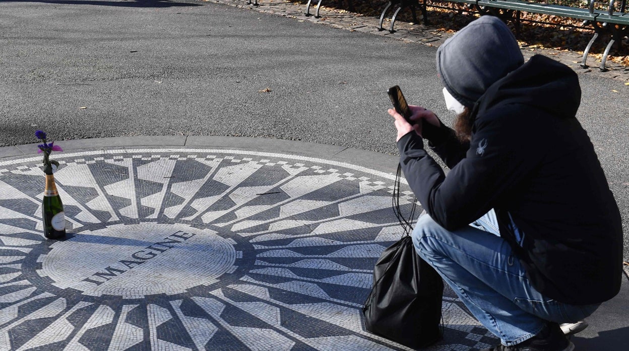 Una mujer toma una foto en el monumento dedicado a John Lennon en Central Park