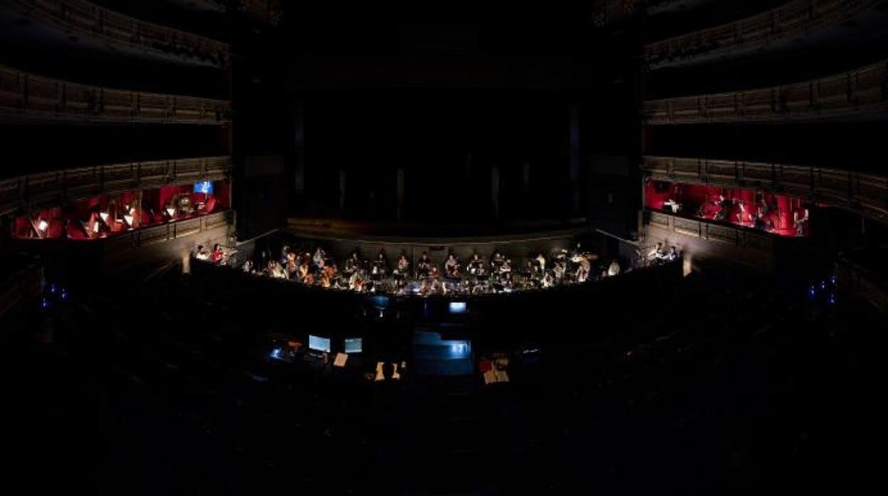 Aspecto del Teatro Real, con los músicos en el foso y fuera de él, durante un ensayo