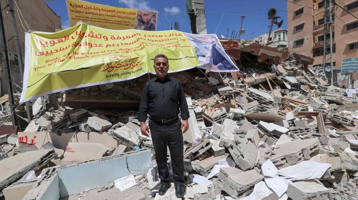 Samir al Mansur, dueño de la librería Al Mansur, posa delante de los escombros a los que quedó reducida tras el bombardeo israelí