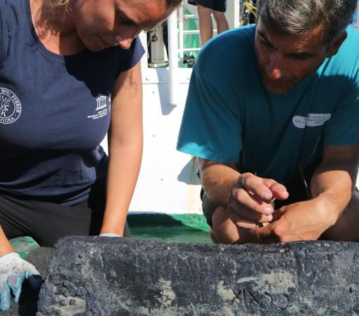 Carlos de Juan examina junto a una compañera un lingote de plomo