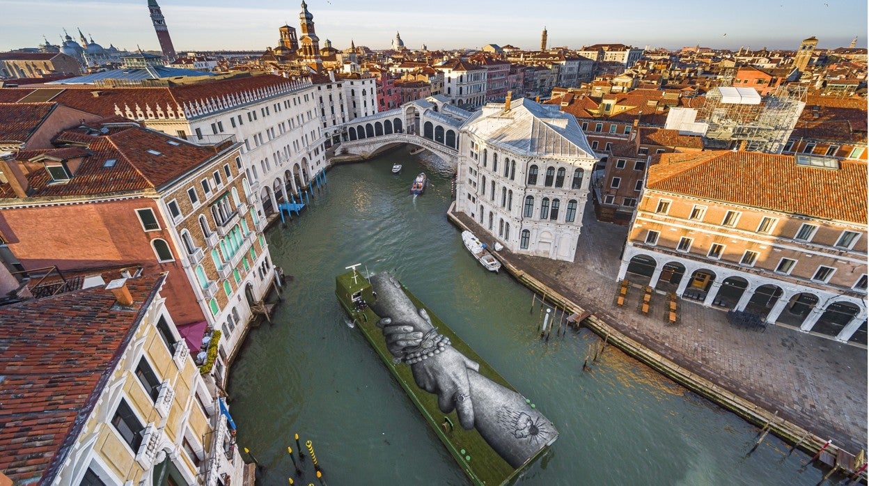 Una pieza del artista Saype navega sobre una barcaza flotante en Venecia, durante Bienal de Arte