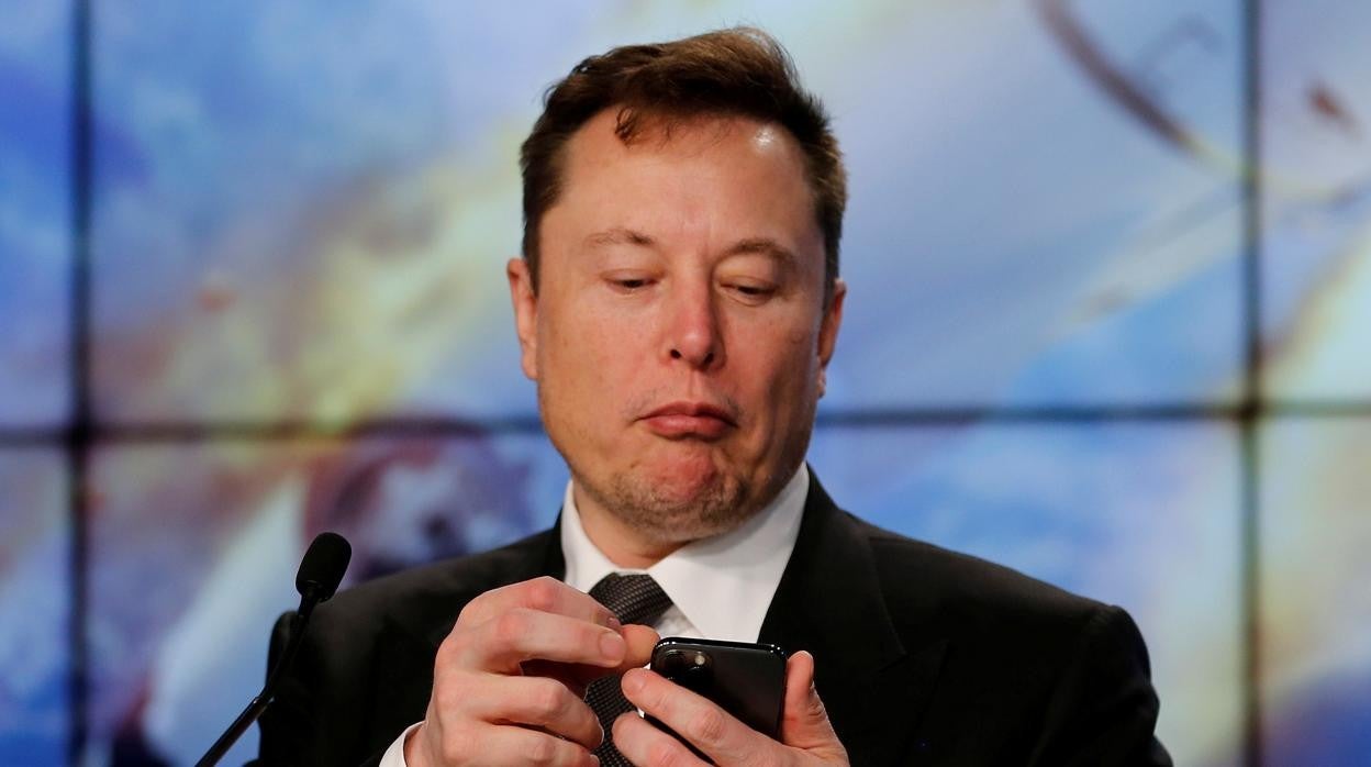 Elon Musk mirando el móvil