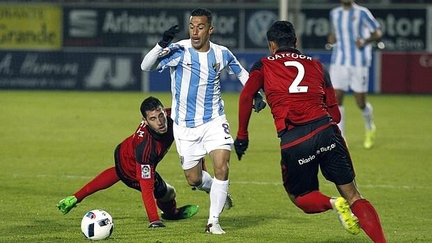 El malaguista Gomes intenta superar a dos rivales del Mirandés