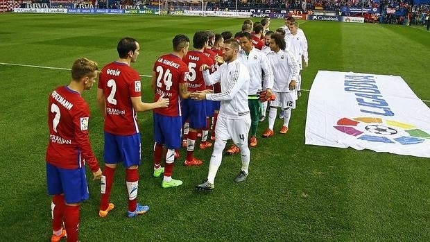 Los jugadores se saludan en el derbi del Calderón