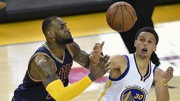 LeBron James y Stephen Curry pelean por un balón en el primer partido de la final de 2015