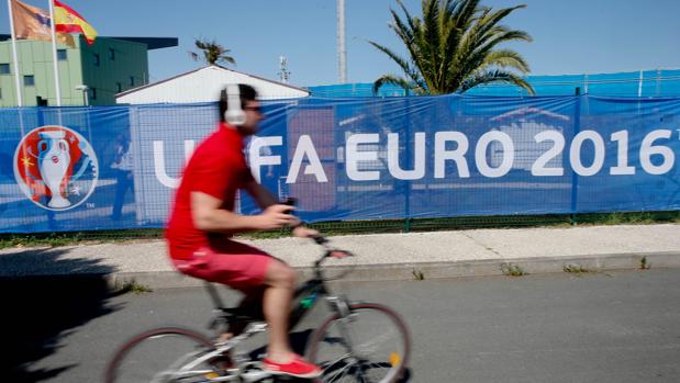 Un hombre pasea en bicicleta junto al campo de entrenamiento de España