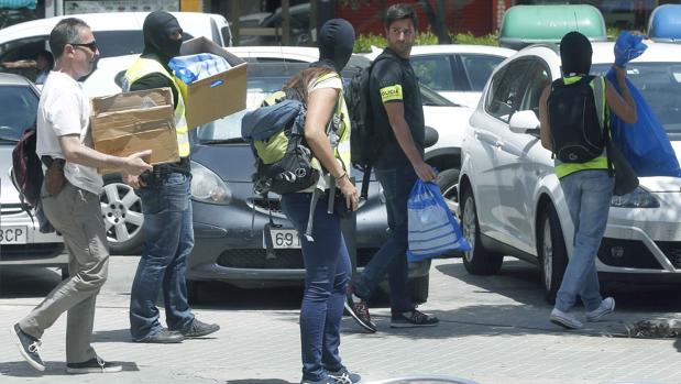 Mossos d'Esquadra transportan cajas con material incautado en el Hotel Arrahona, de Sabadell