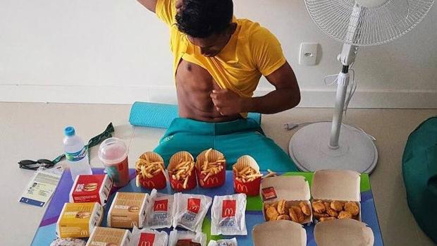 El deportista Sawan Serasinghe, rodeado de comida rápida