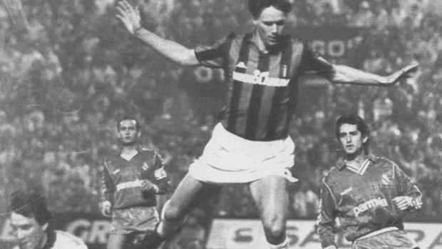 Paco Buyo atrapa un balón ante el jugador del AC Milán Van Basten (centro), observado por Chendo en 1989