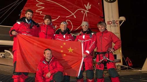 La tripulación del “IDEC Sport” luciendo la bandera China en recuerdo al desparecido Guo Chuan