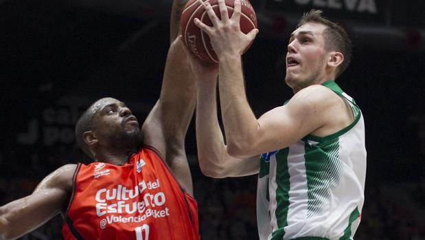 El base serbio del Betis Nikola Radicevic intenta anotar ante el georgiano del Valencia Basket, Will Thomas