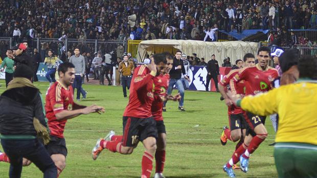 Los jugadores del Al Ahli corren a refugiarse al comenzar los disturbios