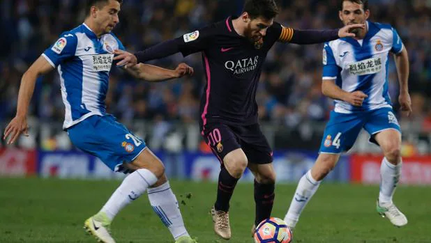 Leo Messi entre Marc Roca y Víctor Sánchez en el último partido entre el Barcelonay el Español