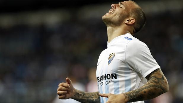 El delanterio del Málaga, Sandro, dispara a puerta frente a un defensa del Celta