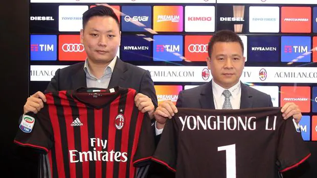 El nuevo propietario del AC Milan, el chino Li Yonghong (derecha), posa con la camiseta del equipo.