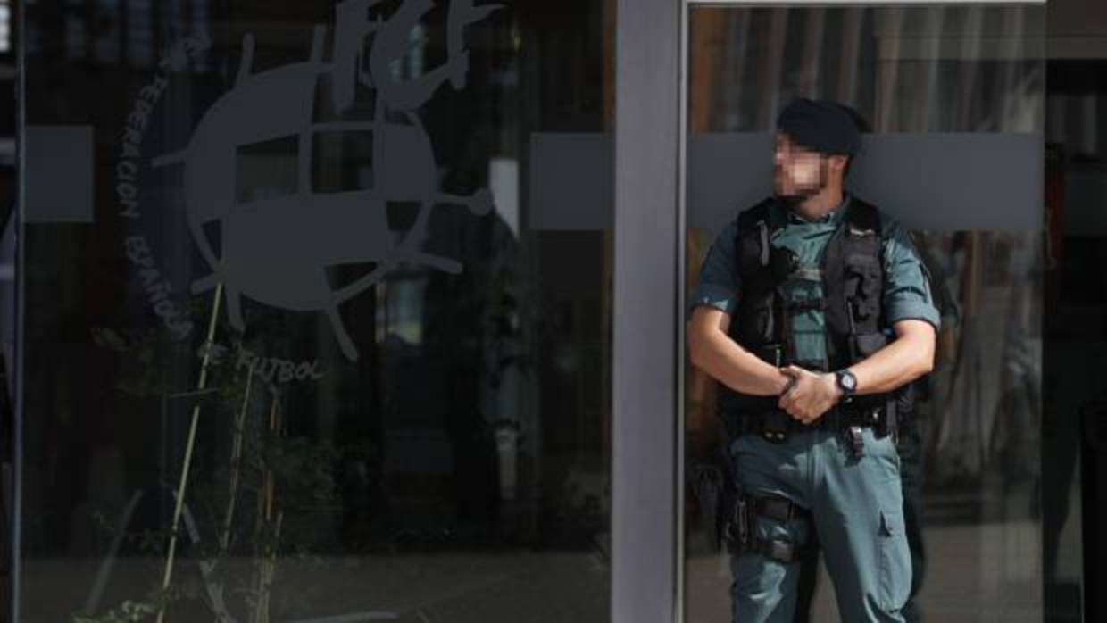 Un gentes de la Guardia Civil custodia el acceso principal de la sede de la Federación